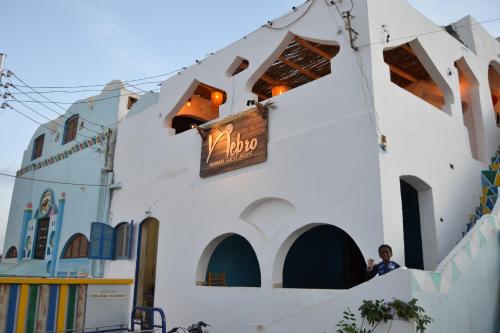 a building with a sign on the side of it at Nebro Nubian Guest House - Adults Only in Aswan