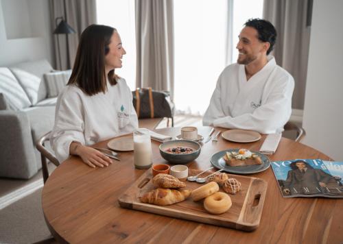 un hombre y una mujer sentados en una mesa con comida en Calderona Wellness, en Bétera