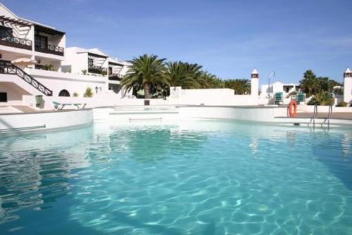a large pool of blue water in front of a building at Casa Paola in Tías