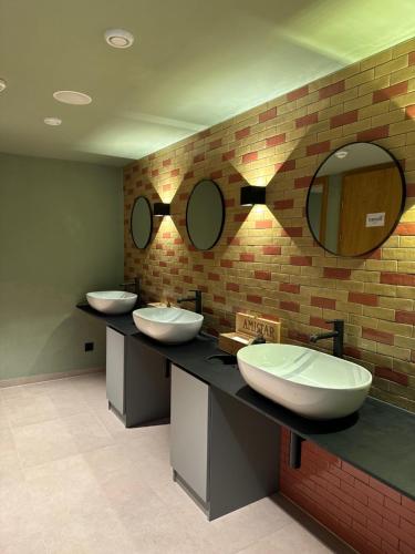 a bathroom with three sinks and two mirrors at Boutiquehotel ZOMM in Seefeld in Seefeld in Tirol
