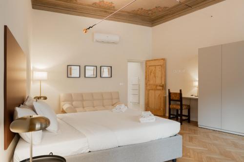 ボローニャにあるAzeglio Luxury roomの大きな白いベッドと机のある寝室