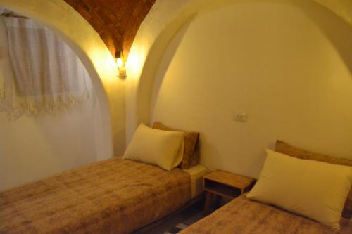 a small room with a bed and a window at Nebro Nubian Guest House - Adults Only in Aswan