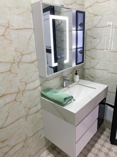 a bathroom with a white sink and a mirror at Camara's Home in Sali Nianiaral