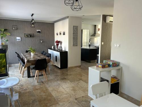 eine Küche und ein Esszimmer mit Tisch und Stühlen in der Unterkunft Villa 200m2, 3 suites, patio avec salle jeux, 1 piscine CHAUFFE DE DEBUT AVRIL A FIN OCTOBRE in Maruéjols