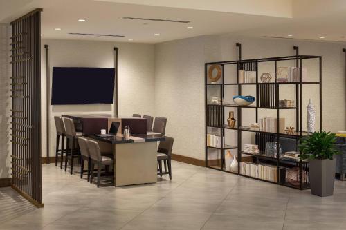 a dining room with a table and chairs and a book shelf at Atlanta Marriott Perimeter Center in Atlanta