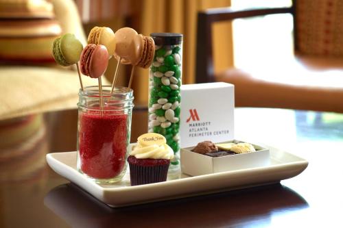 a tray with cupcakes and a plate of cupcakes and a drink at Atlanta Marriott Perimeter Center in Atlanta