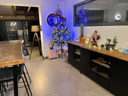 - un salon avec un arbre de Noël bleu dans l'angle dans l'établissement Maison Cosy à la montagne, à Châtillon-de-Michaille
