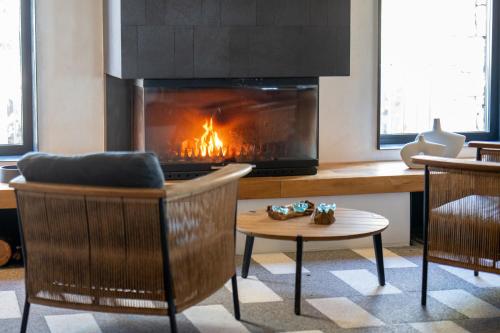 a living room with a fireplace and a chair and a table at Ayvalık Sea Long in Ayvalık