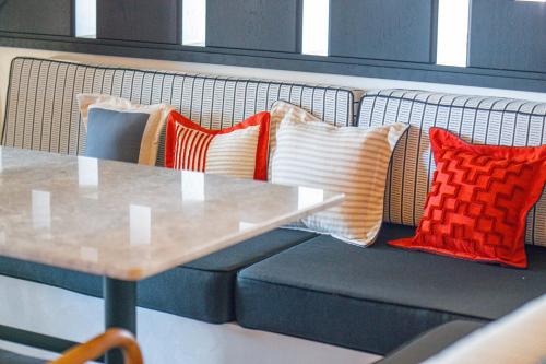 a row of pillows on a bench with a table at Ayvalık Sea Long in Ayvalık