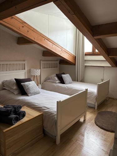 - 2 lits dans une chambre avec une grande fenêtre dans l'établissement Ax 3 Domaines Plateau de Bonascre Charmant duplex face aux pistes avec terrasse, à Ax-les-Thermes