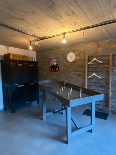 a ping pong table in the middle of a room at Le Scailleteux - Gîte de charme clôturé, accès à la rivière in Fauvillers