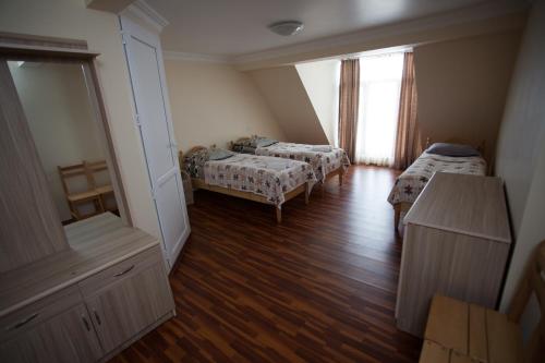a small room with two beds and a window at Mestiatour Guest House in Mestia
