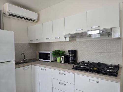 a white kitchen with a stove and a microwave at Bubali Residence in Palm-Eagle Beach