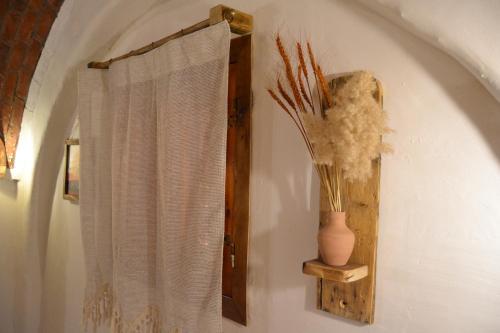 a bathroom with a curtain and a vase on a wall at Nebro Nubian Guest House - Adults Only in Aswan