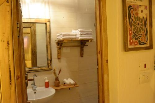 a bathroom with a sink and a mirror and towels at Nebro Nubian Guest House - Adults Only in Aswan
