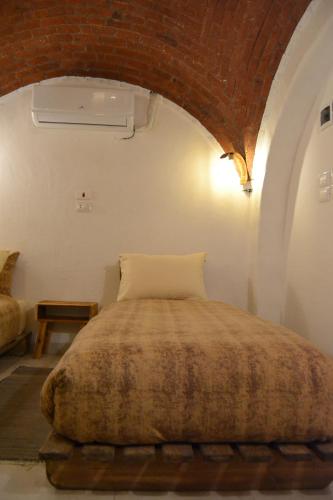 a bed in a room with a brick ceiling at Nebro Nubian Guest House - Adults Only in Aswan