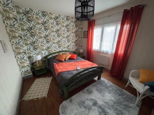 une chambre avec un lit avec des draps orange et une fenêtre dans l'établissement Cozy house, center of Cotentin, à Saint-Sauveur-le-Vicomte