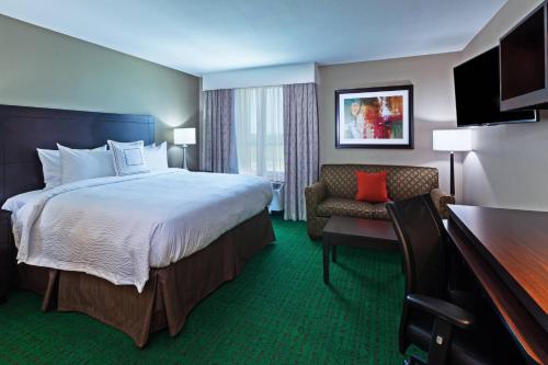 a hotel room with a large bed and a chair at TownePlace Suites by Marriott Abilene Northeast in Abilene
