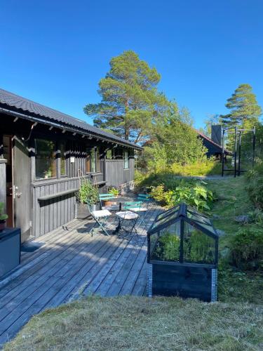a wooden deck with a table and chairs on it at 1960's Architect Villa with Stunning Views in Trondheim