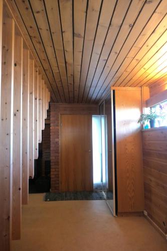 a hallway with a wooden ceiling and a door at 1960's Architect Villa with Stunning Views in Trondheim