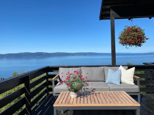 a couch on a deck with a table and flowers at 1960's Architect Villa with Stunning Views in Trondheim