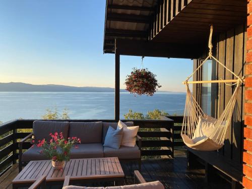 a hammock and a couch on a porch with a view at 1960's Architect Villa with Stunning Views in Trondheim