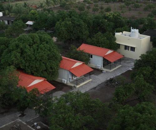 an overhead view of a group of buildings with red roofs at GIR KUTIR Farm and Resort in Chitrāwal