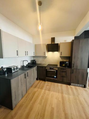 a large kitchen with wooden floors and stainless steel appliances at Kilburn Guest Rooms 167 in London