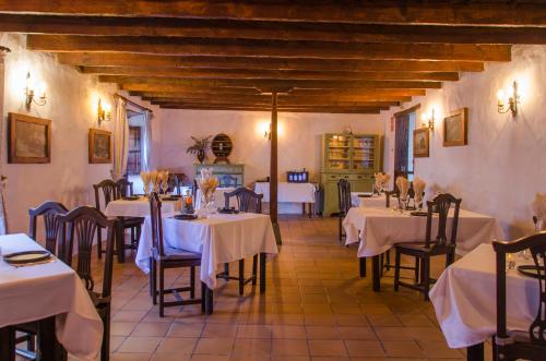 a restaurant with tables and chairs with white tablecloths at Hotel rural casona Santo Domingo in Güimar