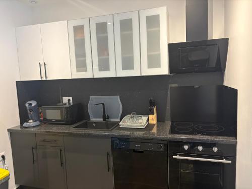 une cuisine avec un comptoir, une cuisinière et un four micro-ondes dans l'établissement Maison à la campagne, à Saint-Thibault