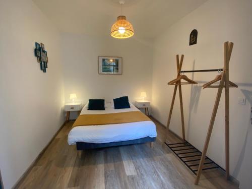een slaapkamer met een bed en twee nachtkastjes bij residence fleurie rdc in Saint-Malo