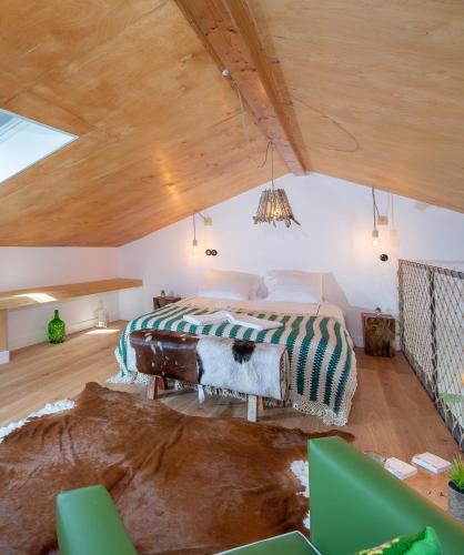 a bedroom with a large bed in a attic at Ribeira d'ilhas Shelter in Santo Isidoro