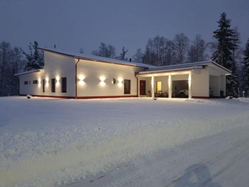 Una casa con mucha nieve delante de ella. en Lapland Villa Ulpukka, en Rovaniemi