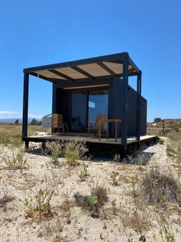 a small black house in the middle of a field at Miramar Tongoy in Tongoy