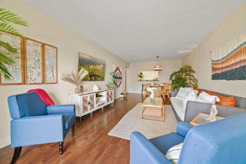 a living room with blue chairs and a couch at Stunning Water Views 1BR Condo with Pool and Tennis Court in Sunny Isles Beach