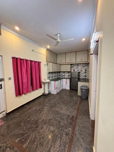 an empty room with red curtains in a room at Marigold Homestay - Mysore in Mysore