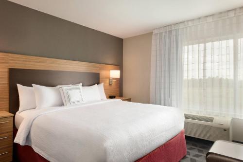 a hotel room with a bed and a window at TownePlace Suites by Marriott Milwaukee Grafton in Grafton