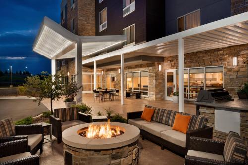 an outdoor patio with a fire pit and a building at TownePlace Suites by Marriott Milwaukee Grafton in Grafton