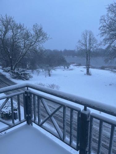 a bridge covered in snow with a field and trees at Ved Holckenhavn Fjord in Nyborg