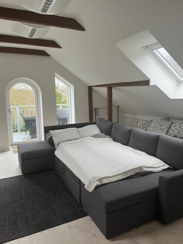 a large bed in a room with a couch at Ved Holckenhavn Fjord in Nyborg