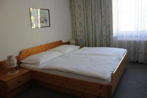a bedroom with a bed with a wooden frame and a window at Gasthof Linko in Traisen