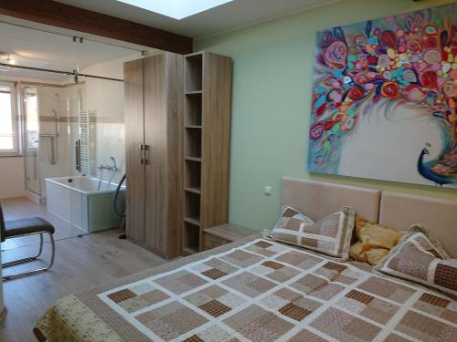 ein Schlafzimmer mit einem Bett und einem Gemälde an der Wand in der Unterkunft Ferienwohnung Harmonie - Zentral in Saalfeld