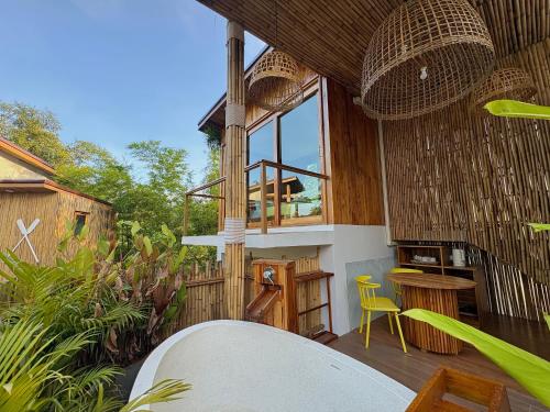 a balcony of a house with a table and chairs at บ้านพราวพร้าว Baan Proud Proud in Khanom