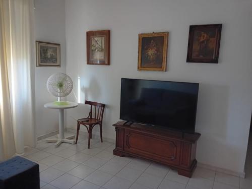 Una sala de estar con un televisor de pantalla plana y una mesa. en Casa Giuseppe, en Génova