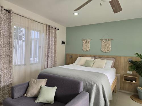 a bedroom with a large bed and a chair at Bubali Residence in Palm-Eagle Beach
