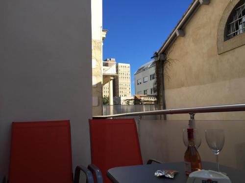 a table with a wine glass sitting on a balcony at Privilège Hôtel & Apparts Eurociel Centre Comédie in Montpellier