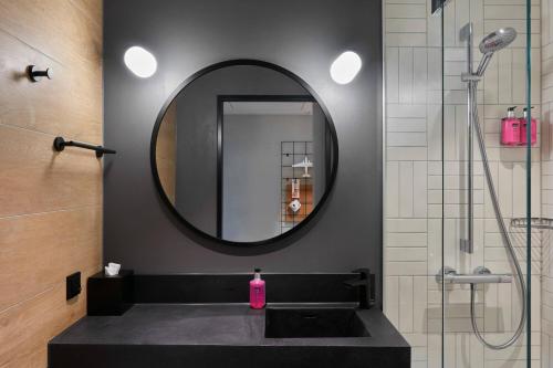 a bathroom with a black sink and a mirror at Moxy Cologne Bonn Airport in Cologne