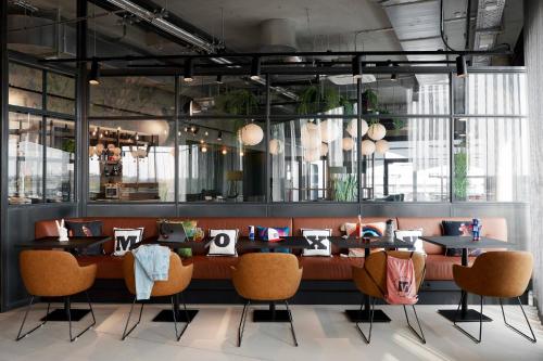 a dining room with a long table and chairs at Moxy Cologne Bonn Airport in Cologne