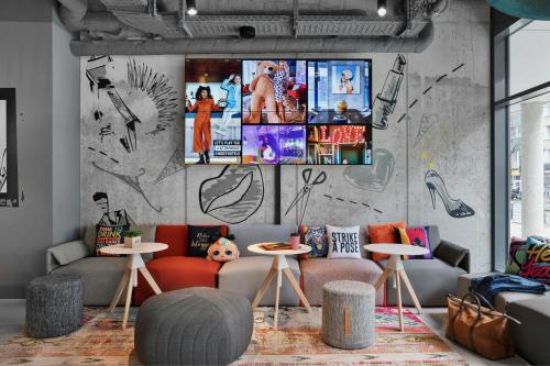 a room with couches and tables and a wall with graffiti at Moxy Duesseldorf City in Düsseldorf