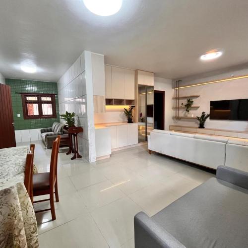 a kitchen and living room with a table and chairs at Casa do vivi in Tramandaí